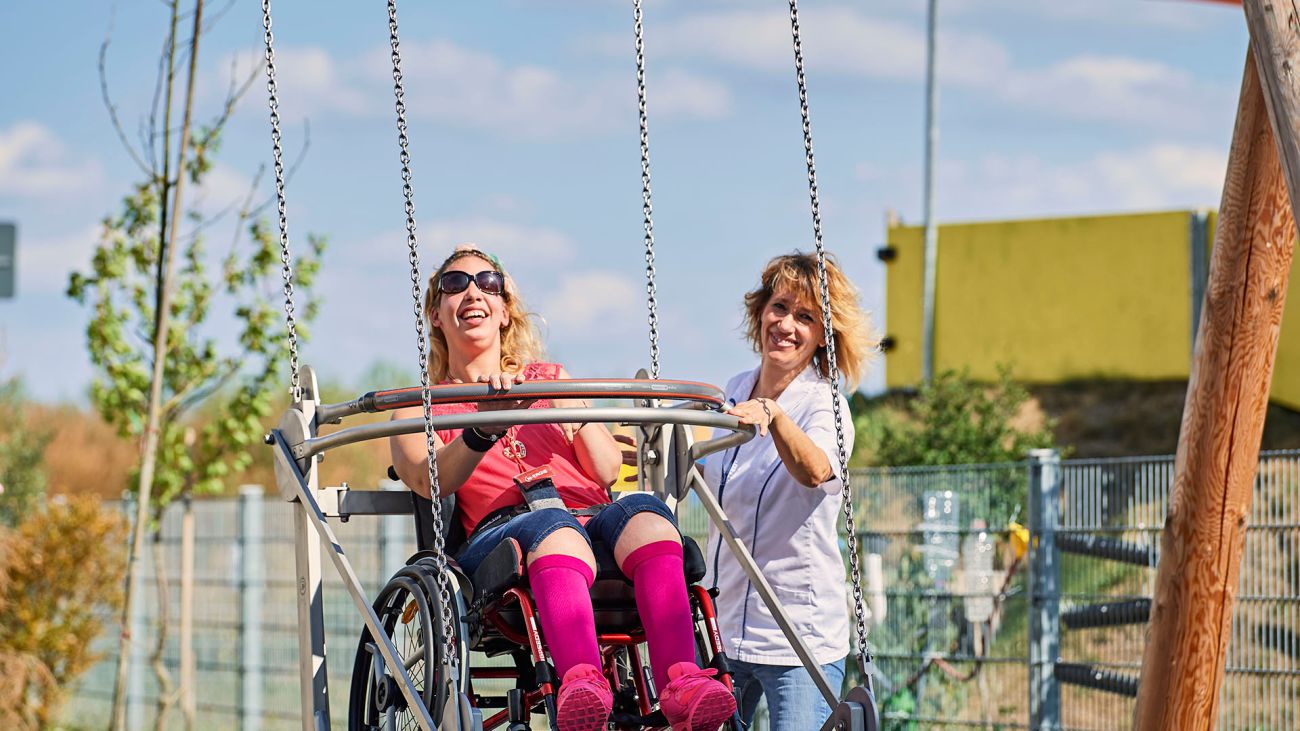 Junge Frau im Rollstuhl auf einer Rollischaukel